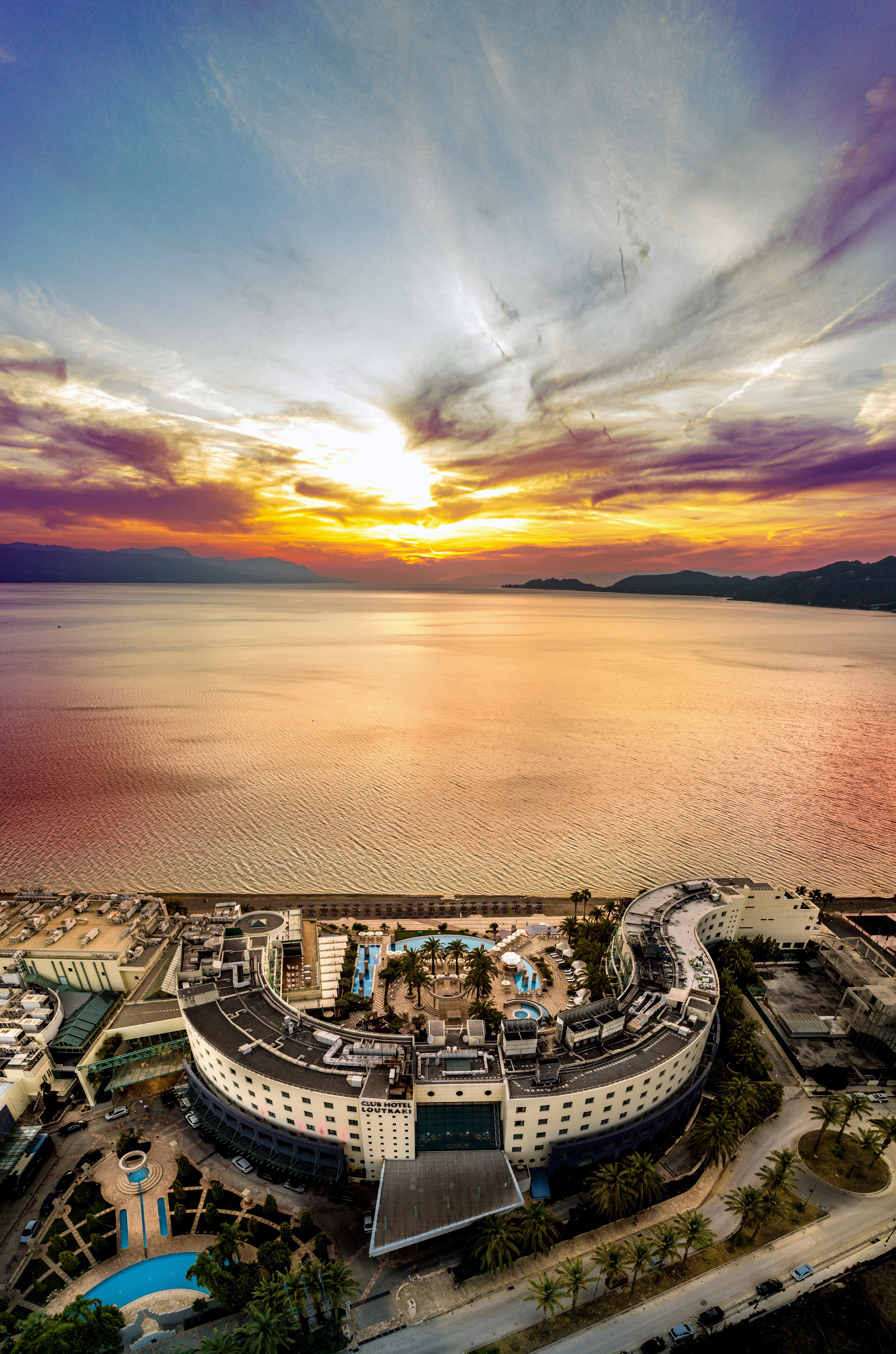 a large building with a sunset in the background