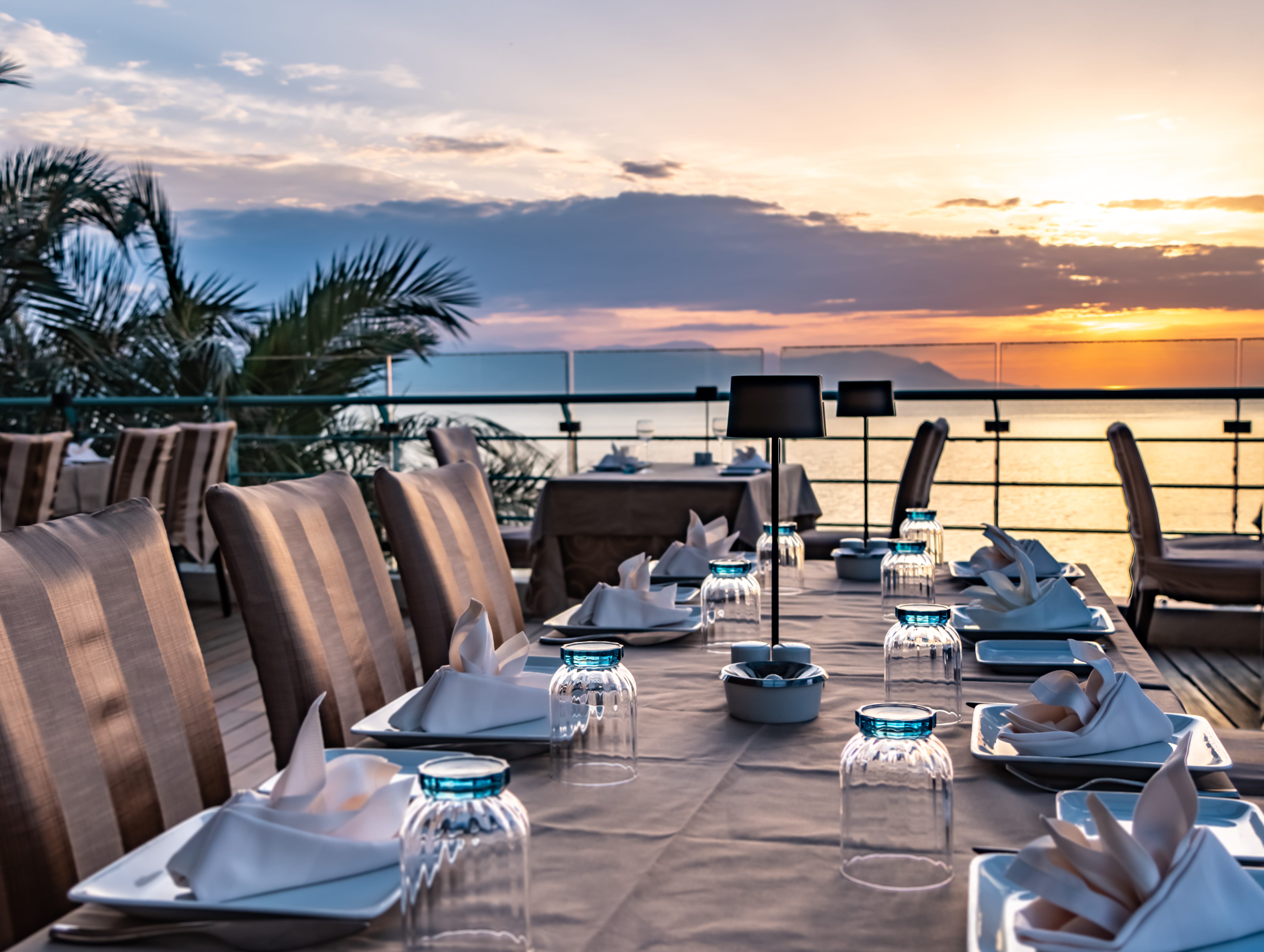 a table with plates and glasses on it by a beach